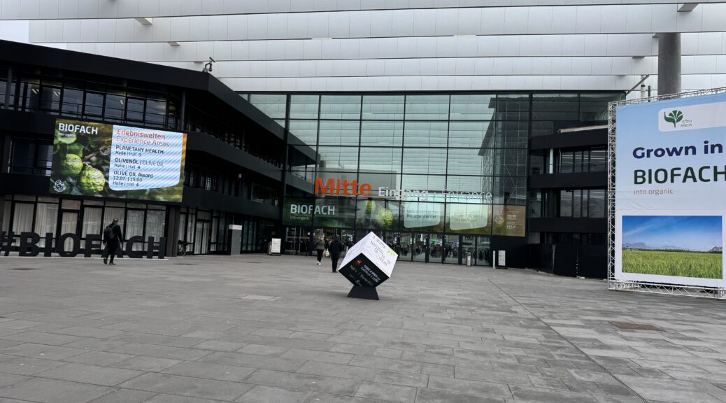 Vor dem Eingang der Messe Biofach. Werbemonitor und Plakat